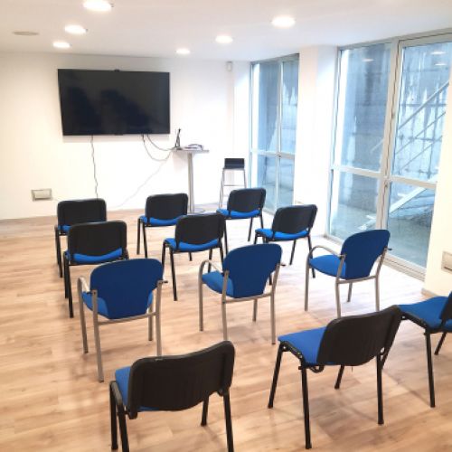 Sala de proyeccciones con sillas y gran pantalla