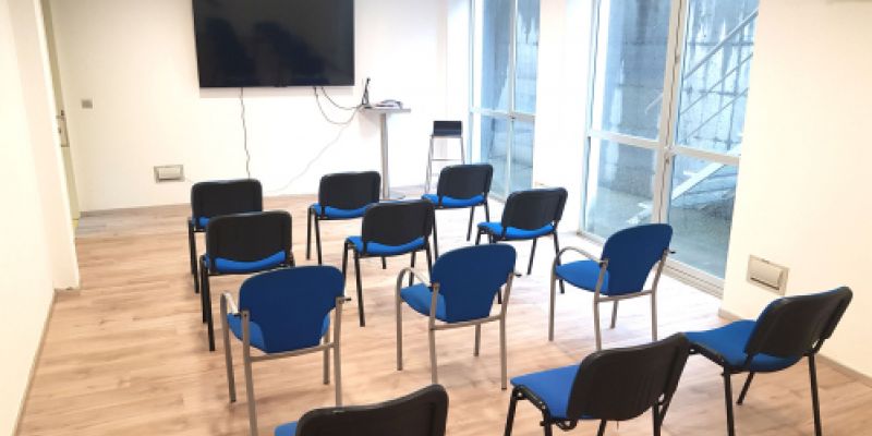 Sala de proyeccciones con sillas y gran pantalla